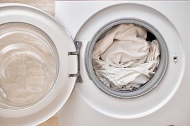 Çamaşır makinesinin içinde kapısı açık beyaz çamaşır makinesi. Kapat..