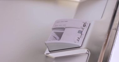 Kadın eli bulaşık makinesi tabletini otomatik bulaşık makinesine koyuyor. Yakın plan.