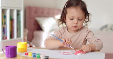 Tatlı küçük kız domuz şeklinde alçıtaşı resmi yapıyor. Yaratıcılık. El yapımı oyuncak.