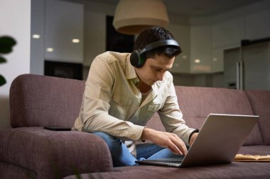 Evde dizüstü bilgisayarla çalışan serbest çalışan adam.