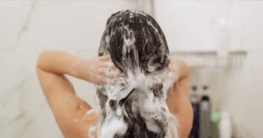 Esmer kadın modern beyaz banyoda ferahlatıcı bir duş alıyor. Saçını yıkayan bir kız.