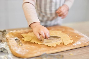 Mutfakta kurabiye bıçağıyla zencefilli kurabiye kesen çocuk elleri. Şenlikli zencefilli kurabiye