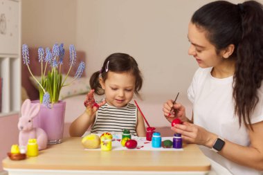 Mutlu anne ve tatlı küçük kız Paskalyayı evde kutlamaya hazırlanıyorlar. Paskalya Aile gelenekleri