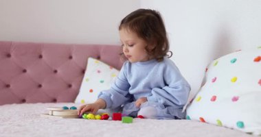 Küçük tatlı kız evde eğitici oyuncaklarla oynuyor, çocuk balık tutuyor.