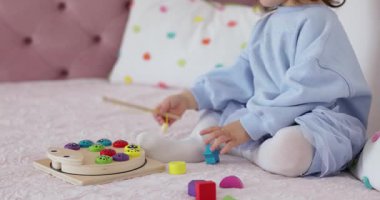 Küçük tatlı kız evde eğitici oyuncaklarla oynuyor, çocuk balık tutuyor.