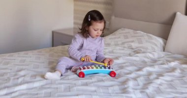 Sevimli küçük kız çocuğu. 3 yaşında. Evde ksilofon çalıyor.