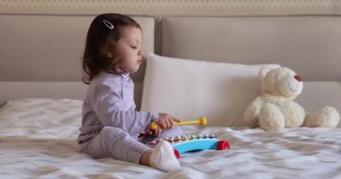 Sevimli küçük kız çocuğu. 3 yaşında. Evde ksilofon çalıyor.