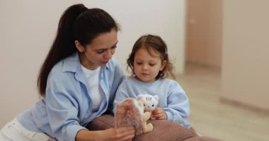 pozitif anne evdeki kanepede bebek bebekle oyuncak oynuyor. geliştirme ve eğitim.