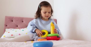 Küçük çocuk renkli piramitlerle evde oynamaya başladı.