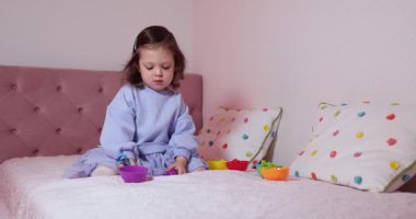 Güzel motor becerileri ve mantığı geliştirmek için renk ayırıcı ile oynayan tatlı bir kız. Evde erken çocuk gelişimi