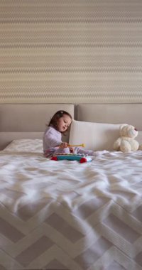 Sevimli küçük kız çocuğu. 3 yaşında. Evde ksilofon çalıyor.