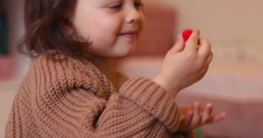 Sevimli küçük kız renkli kille oynuyor. Plastiksin. Hamur oyna, yakın plan.