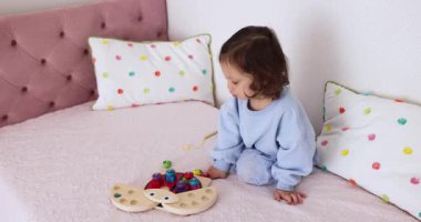 Küçük tatlı kız evde eğitici oyuncaklarla oynuyor, çocuk balık tutuyor.