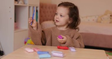 Sevimli küçük kız renkli kille oynuyor. Plastiksin. Hamur oyna