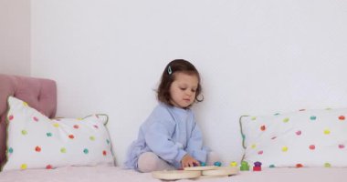 Küçük tatlı kız evde eğitici oyuncaklarla oynuyor, çocuk balık tutuyor.