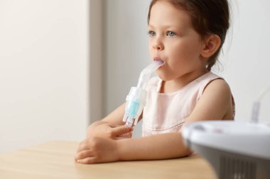 Küçük tatlı kız nebulizörle nefes alıyor, kopyalama alanı.