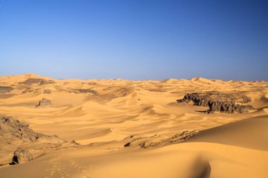 Djanet City, Cezayir 'deki Tadrart Çölü manzaralı ruj tassili najer. Renkli turuncu kum, kayalık dağlar.