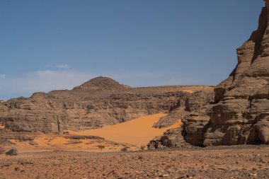 Djanet City, Cezayir 'deki Tadrart Çölü manzaralı ruj tassili najer. Renkli turuncu kum, kayalık dağlar.