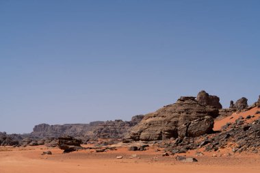 Djanet City, Cezayir 'deki Tadrart Çölü manzaralı ruj tassili najer. Renkli turuncu kum, kayalık dağlar.