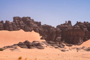 Djanet City, Cezayir 'deki Tadrart Çölü manzaralı ruj tassili najer. Renkli turuncu kum, kayalık dağlar.