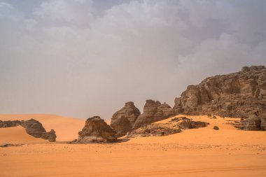 Djanet City, Cezayir 'deki Tadrart Çölü' nde. Renkli turuncu kum, kayalık dağlar.