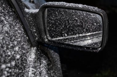 Arabada, dikiz aynası karla kaplı..