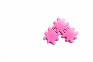 Üç pembe yapboz mükemmel bir şekilde birbirine bağlı, temiz beyaz arka planda kusursuz bir birlik oluşturuyor. Takım çalışmasını, uyumu ve problem çözmeyi sembolize eden canlı ve minimalist bir kavram.