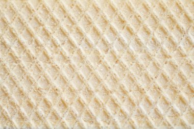 Close-up of a crispy waffle texture, showcasing its golden, grid-like pattern and crunchy surface. Perfect for emphasizing the simplicity and appeal of classic baked treats in food photography or design. clipart