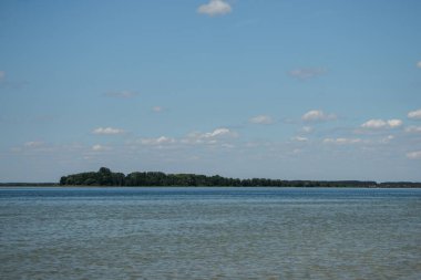 Engin bir göl manzarası. Karşı kıyısı su üzerinde görülebiliyor. Doğanın huzurunu yakalıyor. Seyahat, macera ve manzara fotoğrafçılığı için ideal..