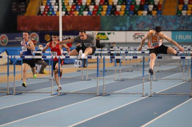 İSTANBUL, TURKEY - 26 Şubat 2022: Atakoy Atletizm Arena 'da düzenlenen Türk Salon Atletizm Şampiyonası sırasında 60 metre engelli koşan sporcular
