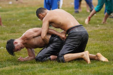 ISTANBUL, TURKIYE - JUNE 11, 2022: Oil wrestlers compete during Etnospor Culture Festival. Oil wrestling also called grease wrestling is the Turkish traditional sport.