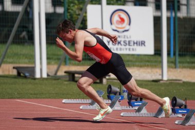 DENIZLI, TURKIYE - 16 Temmuz 2022: Balkan Atletizm Şampiyonası sırasında Denizli Albayrak Atletizm Pisti 'nde 100 metre koşan tanımlanamayan sporcu