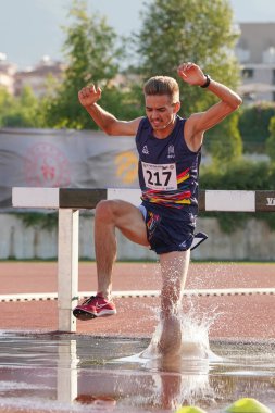 DENIZLI, TURKIYE - 17 Temmuz 2022: Balkan Atletizm Şampiyonası sırasında Denizli Albayrak Atletizm Pisti 'nde 3000 metre engelli koşan tanımlanamayan sporcu