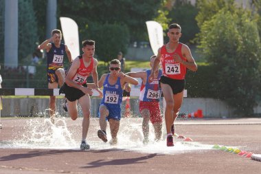 DENIZLI, TURKIYE - 17 Temmuz 2022: Balkan Atletizm U20 Şampiyonası sırasında Denizli Albayrak Atletizm Pisti 'nde 3000 metre engelli koşan sporcular