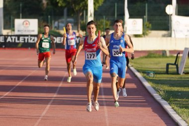 DENIZLI, TURKIYE - 17 Temmuz 2022: Balkan Atletizm Şampiyonası sırasında Denizli Albayrak Atletizm Pisti 'nde 4x400 metre bayrak koşan sporcular