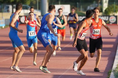 DENIZLI, TURKIYE - 17 Temmuz 2022: Balkan Atletizm Şampiyonası sırasında Denizli Albayrak Atletizm Pisti 'nde 4x400 metre bayrak koşan sporcular