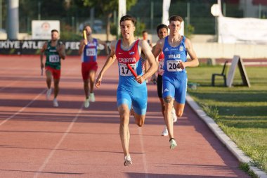 DENIZLI, TURKIYE - 17 Temmuz 2022: Balkan Atletizm Şampiyonası sırasında Denizli Albayrak Atletizm Pisti 'nde 4x400 metre bayrak koşan sporcular