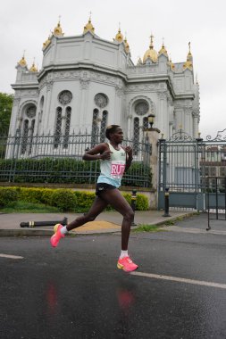 İSTANBUL, TURKIYE - 28 Nisan 2024: Fener ilçesinin tarihi caddesinde İstanbul 'da yarı maraton koşan sporcu