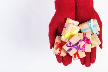 Yünlü eldiven giymiş kadınların elleri ve Noel için paketlenmiş hediyeler, sevgililer günü, doğum günü veya diğer kutlamalar, metin için kopya alanı