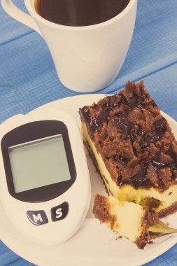 Şeker seviyesini ölçmek ve ölçmek için glikoz ölçer ve sade kahveli taze pişmiş cheesecake. Diyabet ve diyet