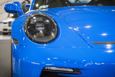 Poznan, Polonya - 08 Nisan 2022: Poznan Motor Fuarı. Mavi Porsche 911 'in ön lambasına bakın. Ayrıntı ve aracın parçası