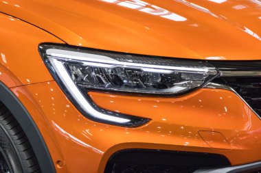 Poznan, Polonya - 08 Nisan 2022: Poznan Motor Fuarı. Turuncu Renault Arkana 'nın parlayan lambalarına bakın. Ayrıntı ve aracın parçası