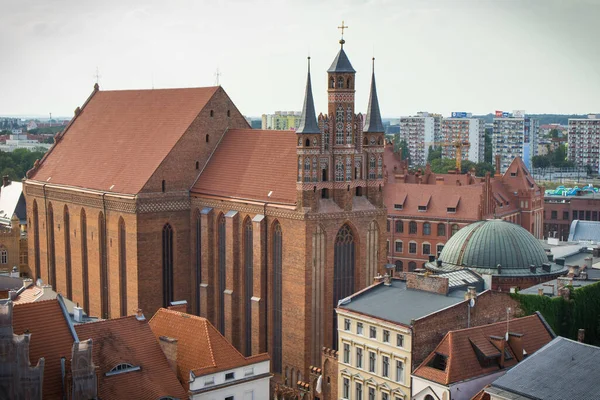 stock image Torun, Poland - August 19, 2022: View from tower on church of Assumption of Blessed Virgin Mary and other old or modern buildings in center of polish city Torun