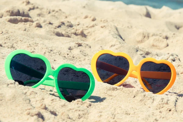 海滩上的沙地上挂着五颜六色的太阳镜 日光浴时防晒 旅行和休假时间概念 — 图库照片