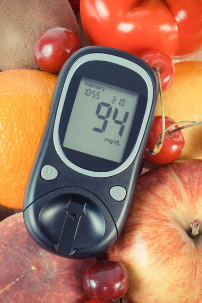 Glucometer with result of measurement sugar level and fresh ripe natural fruits and vegetables. Nutritious food containing healthy minerals and vitamins