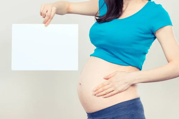 Беременная Женщина Держит Пустую Белую Карточку Смс Ожидаю Новорожденного Расширение — стоковое фото