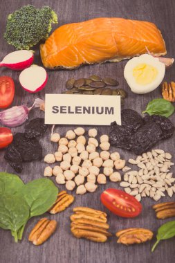 Selenyum, diyet lifleri ve diğer çeşitli vitamin ve mineraller içeren sağlıklı yiyecekler. Siyah tahta arkaplan