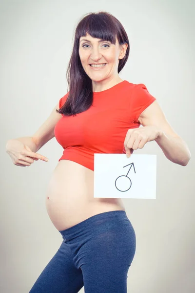 男性のシンボルを持つ妊娠中の白いカードを保持している女性 男の子の誕生を期待している 家族を拡大する — ストック写真