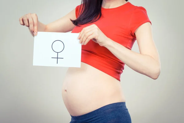 Zwangere Vrouw Met Een Witte Kaart Met Vrouwelijk Symbool Verwacht — Stockfoto