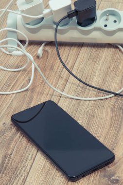 Akıllı telefon, cep telefonu ve elektrik hattına bağlı şarj cihazları. Çeşitli aygıtlar şarj ediliyor